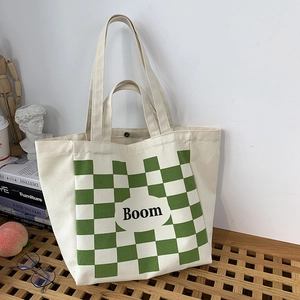 Close-up of canvas tote bag with green checkerboard pattern and magnetic snap closure