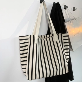Detail shot of black and white striped canvas tote with durable metal snap fastener