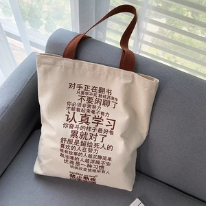 Detailed texture of beige canvas tote bag with thick brown cotton handles on gray sofa