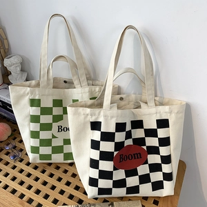 Detail of checkered canvas tote bags in green and black featuring magnetic snap closure