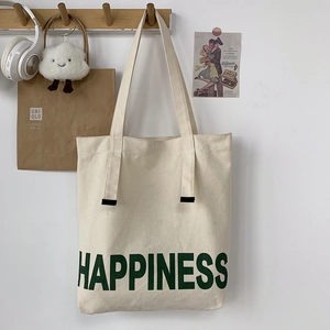 Grand sac fourre-tout en toile blanc cassé avec texte Happiness vert sur un crochet