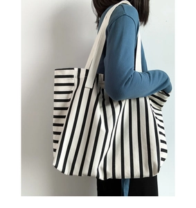 Side view of striped canvas tote bag showing large capacity and comfortable shoulder straps