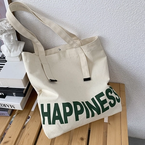 Détail du sac cabas en toile avec imprimé Happiness vert et fermoir magnétique en métal