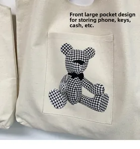 Close-up of front pocket on white canvas tote bag with houndstooth bear pattern