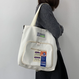 Detail der weißen Nylon-Einkaufstasche mit Boardingpass- und Warnaufklebern-Patches