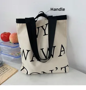 Detail of a thick cream canvas tote bag with black letter print and reinforced handle