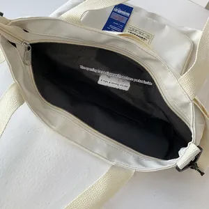 Detailansicht der weißen Segeltuchtasche mit Silberreißverschluss und schwarzem Futter