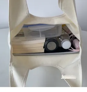 Top view of cream canvas tote bag showing large capacity for laptop, books and water bottle