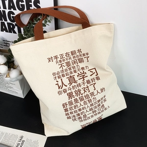 Detail of canvas tote bag with brown woven handles and motivational Chinese typography