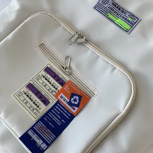 Nahaufnahme der cremeweißen Nylontasche mit Vordertaschen und Streetstyle-Aufnähern