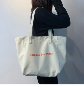 Détail du grand sac cabas en toile avec lettrage orange pour un usage quotidien