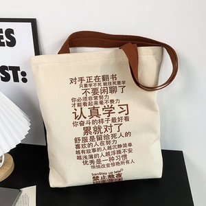 Close-up of off-white canvas tote bag with brown straps and creative Chinese text