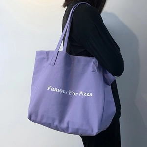 Vue latérale du grand sac cabas en toile violette avec texte porté par un mannequin