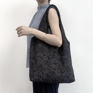 Détail du sac cabas jacquard noir avec texture florale de rose en relief 3D sur tissu
