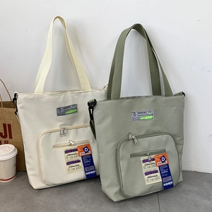 Detailaufnahme großer Nylon-Tragetaschen mit Industrie-Labels und Reißverschlusstaschen