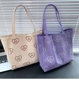 Gros plan de sacs fourre-tout en toile à motifs de cœurs avec texte Tu es aimé