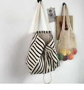Detail shot of the striped canvas tote bag showing interior lining and magnetic snap closure