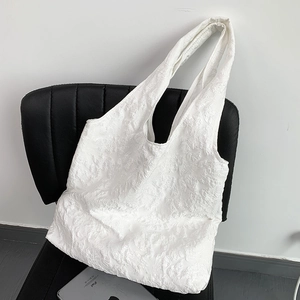 Détail du sac cabas blanc avec texture jacquard en relief et bandoulière large