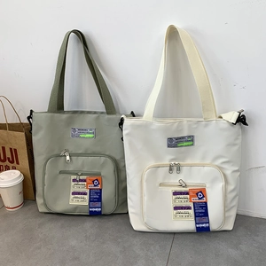 Details von wasserdichten Nylon-Tote-Bags in Olivgrün und Beige mit praktischen Außentaschen