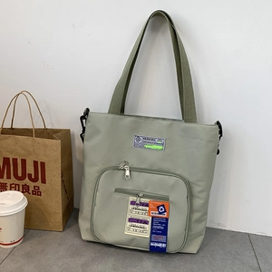 Detailansicht der grünen Nylon-Tasche mit verstellbarem Gurt und gewebten Patches