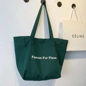 Détail du sac fourre-tout en toile vert foncé avec imprimé Famous For Pizza et bandoulière