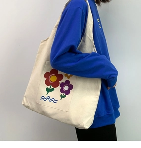 Detail view of large white canvas tote bag featuring vibrant floral happy birthday print