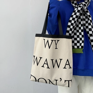 Minimalist canvas tote bag with bold black letters and durable black shoulder straps