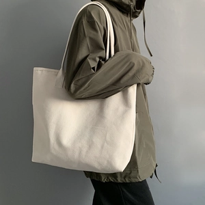 Close-up of minimalist large white canvas tote bag showing thick texture on shoulder