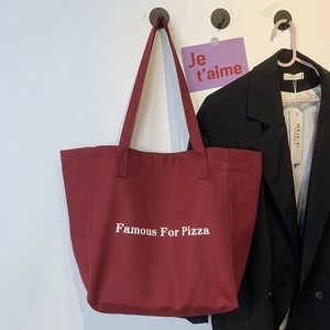 Détail du cabas en toile bordeaux avec impression de texte blanc Famous For Pizza