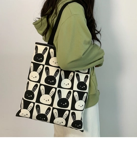 Detail of canvas tote bag showing black and white checkerboard pattern and bunny prints