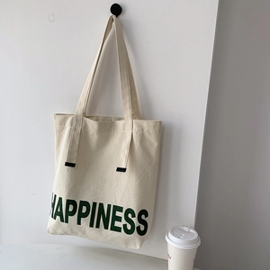 Vue détaillée du sac fourre-tout en toile avec lettrage Happiness en vert