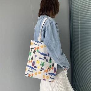 Detailed view of white canvas tote bag with tropical Hawaii prints and shoulder straps