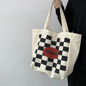 Detailed shot of large checkerboard canvas tote bag with red Boom logo embroidery