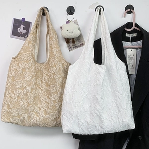 Détail de la texture brodée jacquard floral sur un sac cabas chic avec larges anses