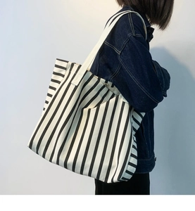 Detailed view of the large capacity striped canvas tote bag with magnetic metal clasp