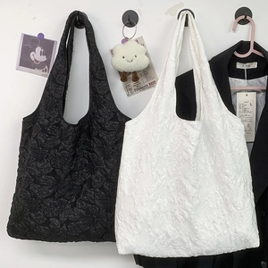 Détail de sacs fourre-tout noir et blanc avec jacquard floral et longues anses de transport