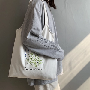 Detail of white canvas tote bag with lavender print on a textured grey background