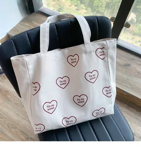 Détail du sac fourre-tout en toile avec motif cœur rouge et texte Tu es aimé
