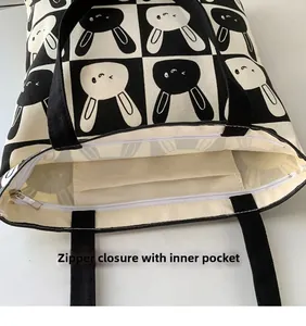 Detail view of the canvas tote bag showing the zipper closure and internal storage pocket