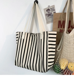 Hanging striped canvas tote bag detail featuring thick cotton fabric and durable handles