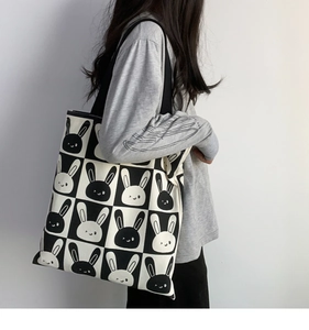 Detail of a large canvas tote bag with black and white checkered rabbit patterns