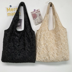 Gros plan sur la broderie florale des sacs fourre-tout minimalistes noir et blanc