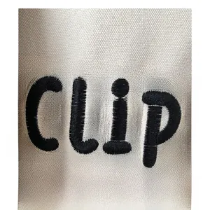Macro shot of detailed black CLIP embroidery on premium off-white canvas fabric