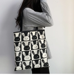 Detail of cute bunny pattern canvas tote bag shown on shoulder in daily usage scenario