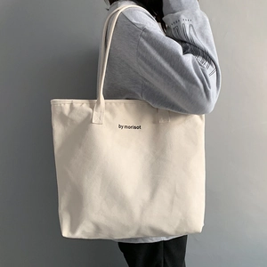 Detail of a cream canvas tote bag with by morisot print and spacious shoulder straps