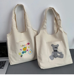 Detail view of large canvas tote bags featuring spring floral and bear print patterns