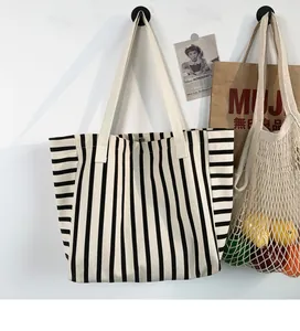 Detail shot of black and white striped canvas tote with durable metal snap button closure