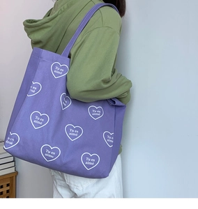 Détail du sac cabas en toile violette avec imprimé cœur Tu es aimé et bandoulière