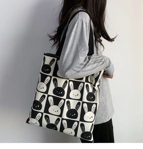 Detail shot of a black and white checkerboard canvas tote bag with cute rabbit print