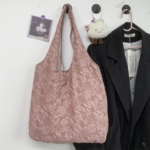 Vue détaillée du texte jacquard floral 3D rose sur un grand sac cabas minimaliste